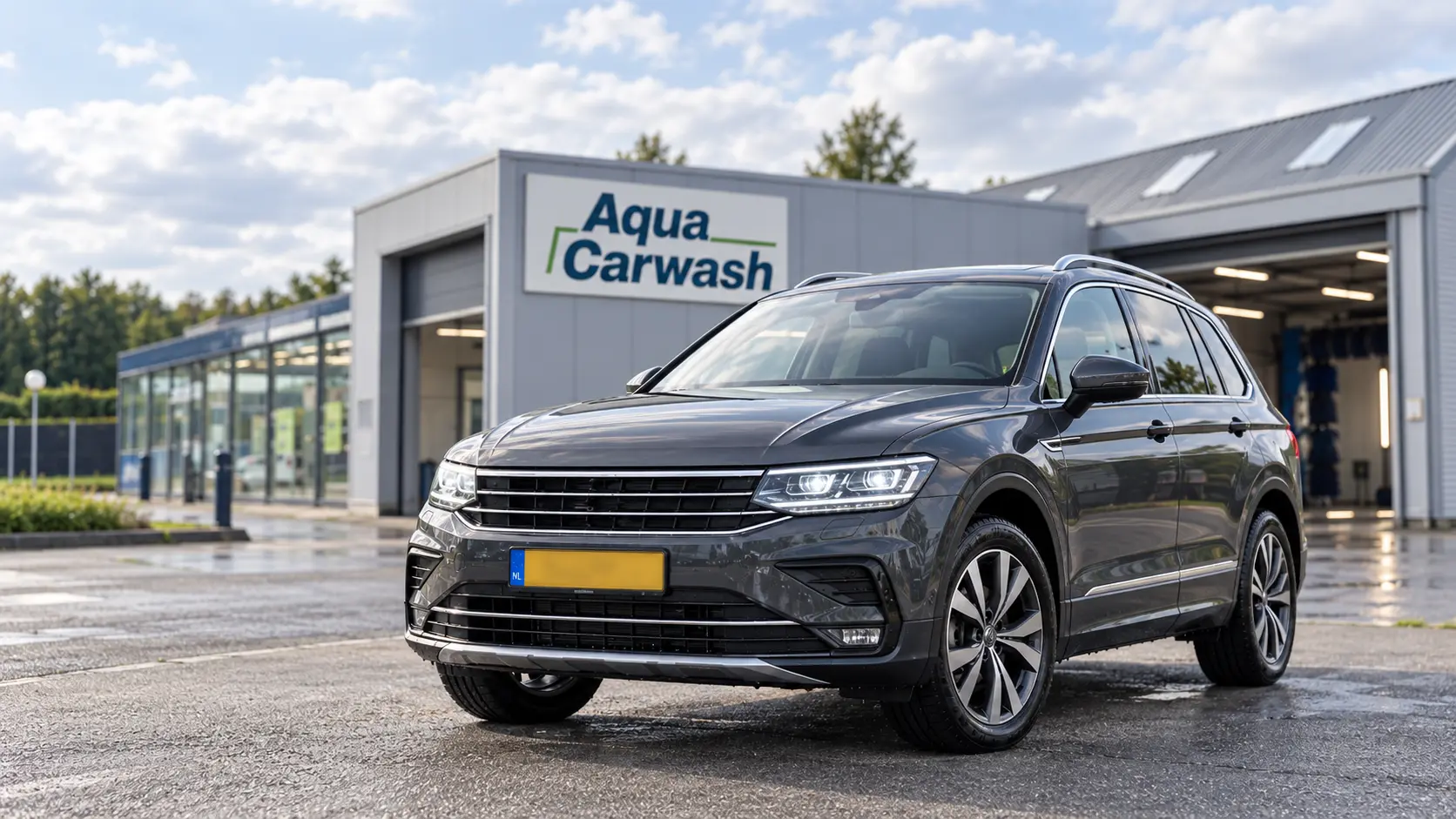 Het terrein van Aqua Carwash in Leeuwarden met een schone auto voor het gebouw en de wasstraat